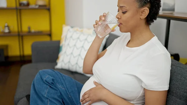 Mladá Těhotná Žena Pije Sklenici Vody Sedí Pohovce Doma — Stock fotografie