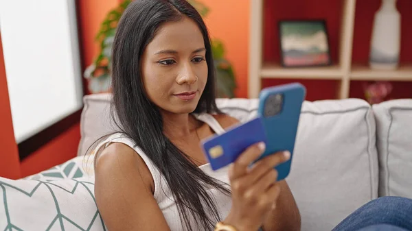 アフリカ系アメリカ人女性のショッピングでスマートフォンやクレジットカードを自宅でソファに座って — ストック写真