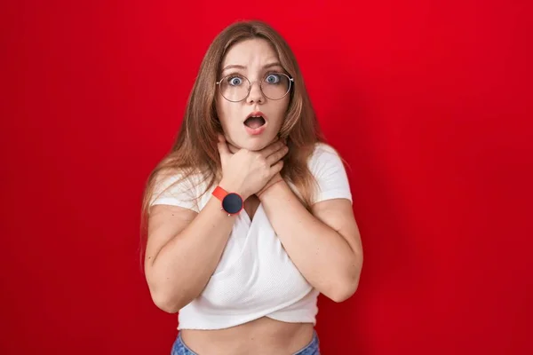 Young Caucasian Woman Standing Red Background Shouting Suffocate Because Painful — Stock Photo, Image