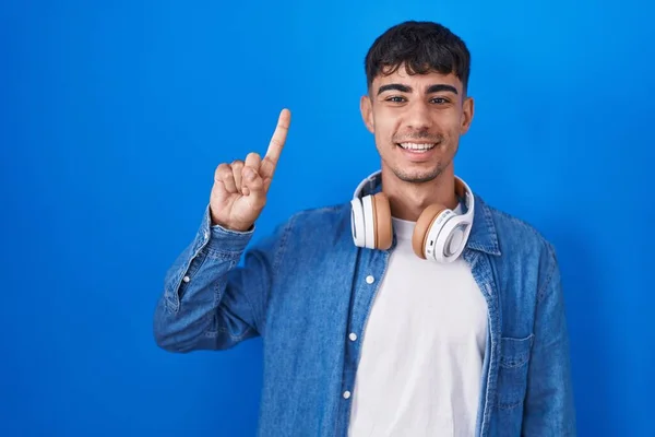 Young Hispanic Man Standing Blue Background Showing Pointing Finger Number — Fotografia de Stock