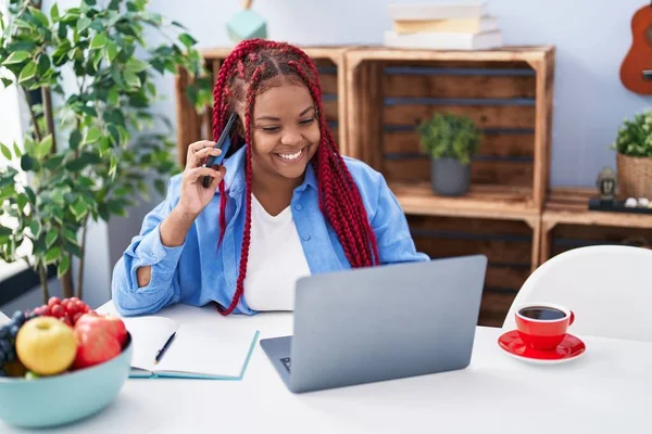 African American Woman Talking Smartphone Using Laptop Home — Stok fotoğraf