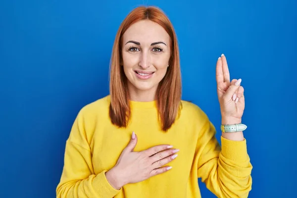 Young Woman Standing Blue Background Smiling Swearing Hand Chest Fingers — ストック写真
