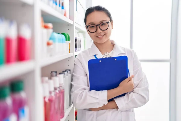 Young Chinese Woman Pharmacist Smiling Confident Holding Clipboard Pharmacy — Foto Stock