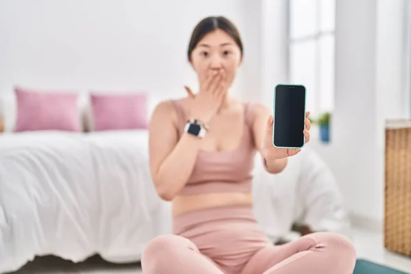 スマートフォンを持っている中国の若い女性は 手で口を覆い ショックを受け 間違いを恐れている 驚きの表情 — ストック写真