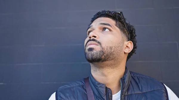 stock image African american man looking to the side with serious expression over isolated black background