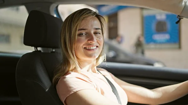 Νεαρή Ξανθιά Γυναίκα Χαμογελά Αυτοπεποίθηση Οδήγηση Αυτοκινήτου Στο Δρόμο — Φωτογραφία Αρχείου