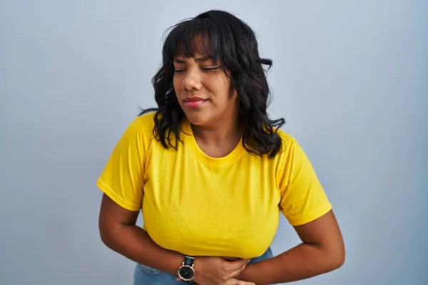 ヒスパニック系の女性の胃の上に手で青の背景の上に立って消化不良 痛みを伴う病気も感じている キャッシュ コンセプト — ストック写真