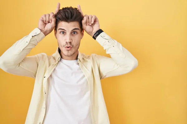 Young Hispanic Man Standing Yellow Background Doing Funny Gesture Finger — Foto Stock