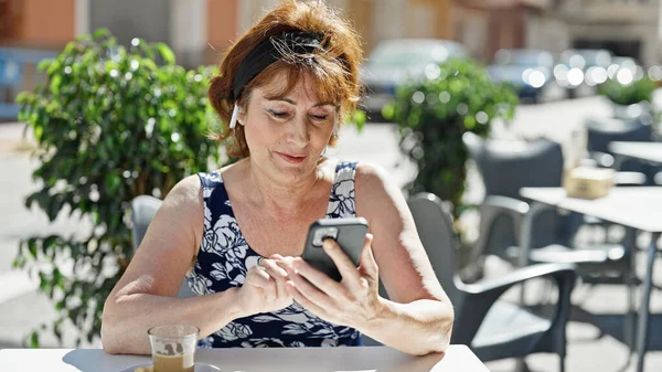 Μεσήλικη Γυναίκα Που Χρησιμοποιεί Smartphone Και Ακουστικά Στη Βεράντα Του — Φωτογραφία Αρχείου