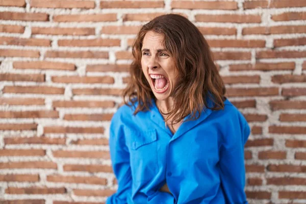 Beautiful Brunette Woman Standing Bricks Wall Angry Mad Screaming Frustrated — Stock Photo, Image