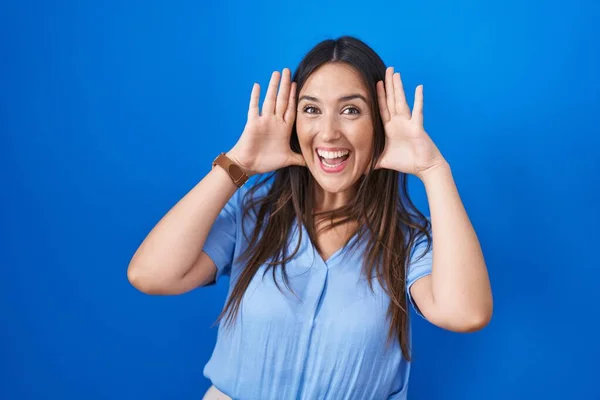 Jonge Brunette Vrouw Staan Blauwe Achtergrond Glimlachend Vrolijk Spelen Gluren — Stockfoto