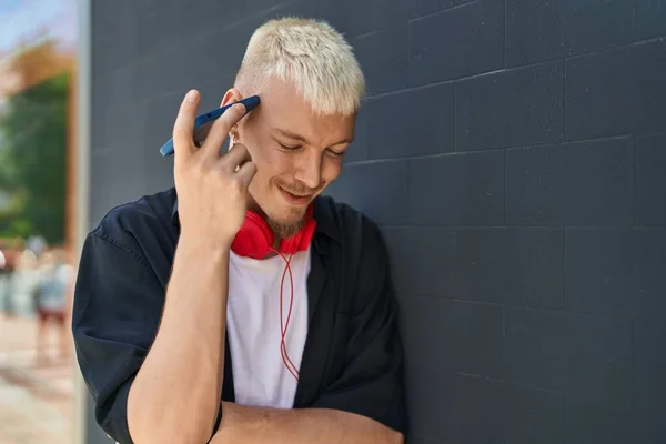 Young Caucasian Man Listening Audio Message Wearing Headphones Street —  Fotos de Stock