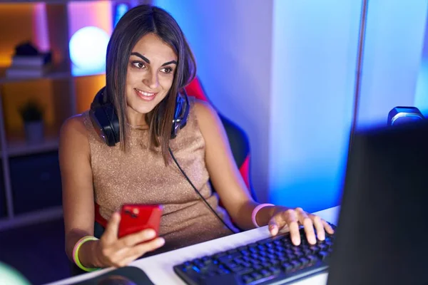 ゲームルームでコンピュータやスマートフォンを使用して若い美しいパニック女性ストリーマー — ストック写真