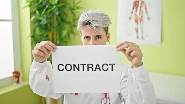 Young woman doctor holding contract paper at clinic