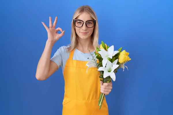 Mladá Běloška Květinářské Zástěře Držící Květiny Pozitivním Úsměvem Dělá Dobře — Stock fotografie