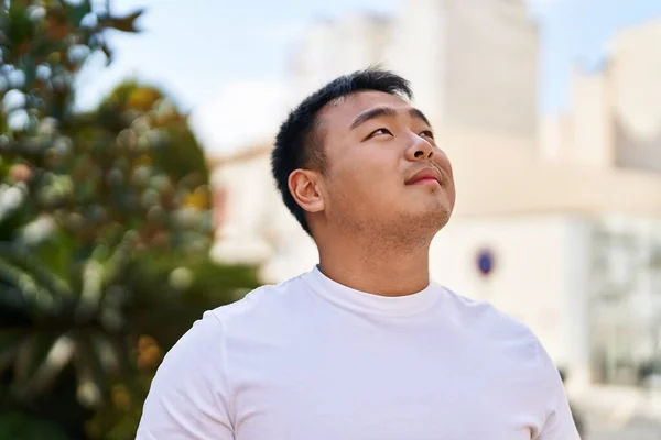 Młody Chińczyk Uśmiecha Się Pewnie Patrząc Niebo Ulicy — Zdjęcie stockowe