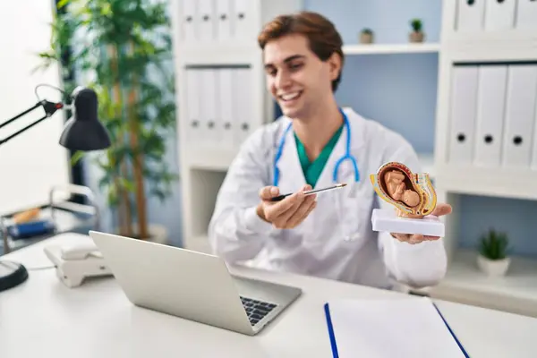 Young Caucasian Man Doctor Holding Anatomical Model Uterus Fetus Speaking — Stockfoto