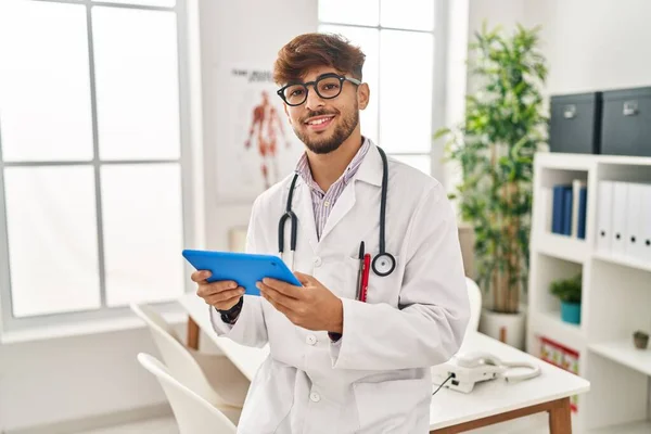Young Arab Man Wearing Doctor Uniform Using Touchpad Working Clinic — Stok fotoğraf
