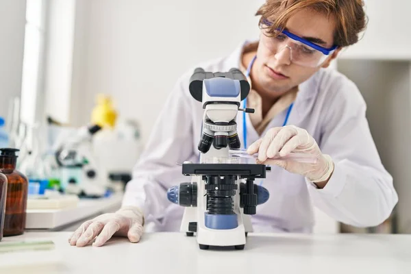 Young Caucasian Man Scientist Using Microscope Pouring Liquid Sample Laboratory — Stock Photo, Image