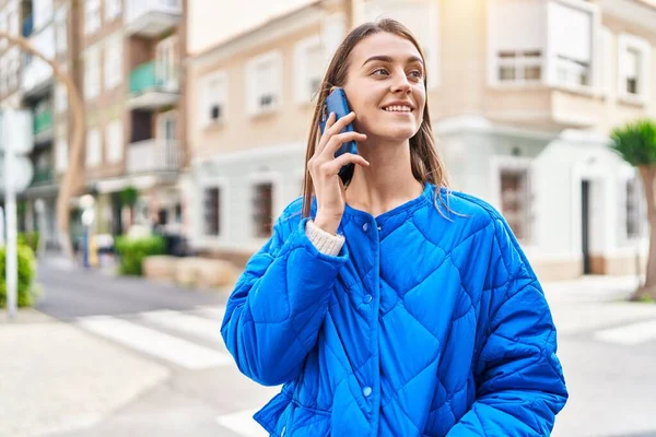 若い白人女性が自信を持って路上でスマートフォンで話して笑っている — ストック写真