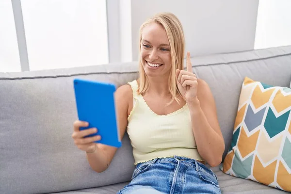 Mladá Běloška Používající Touchpad Sedící Pohovce Usmívající Myšlenkou Nebo Otázkou — Stock fotografie