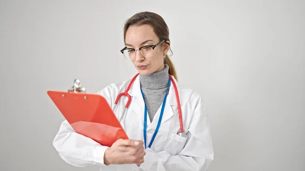 年轻的高加索女医生在隔离的白色背景下阅读剪贴板上的文档 — 图库照片