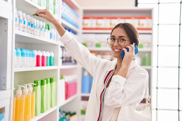 Young Beautiful Hispanic Woman Customer Smiling Confident Talking Smartphone Pharmacy — Stockfoto