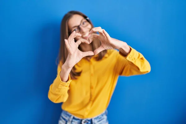 Mujer Joven Con Gafas Pie Sobre Fondo Azul Sonriendo Amor — Foto de Stock