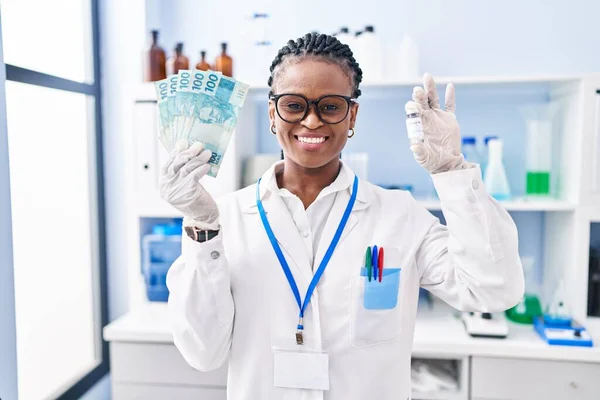 顔に幸せとクールな笑顔で笑顔でお金を保持する科学研究所で働いている点字を持つアフリカの女性 歯を見せて — ストック写真