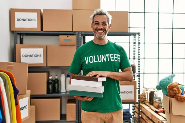 Hombre Pelo Gris Mediana Edad Voluntario Sonriendo Confiado Sosteniendo Libros —  Fotos de Stock
