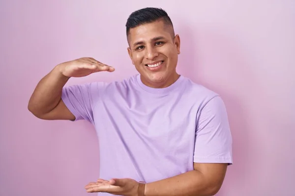 Young Hispanic Man Standing Pink Background Gesturing Hands Showing Big — Stock Photo, Image