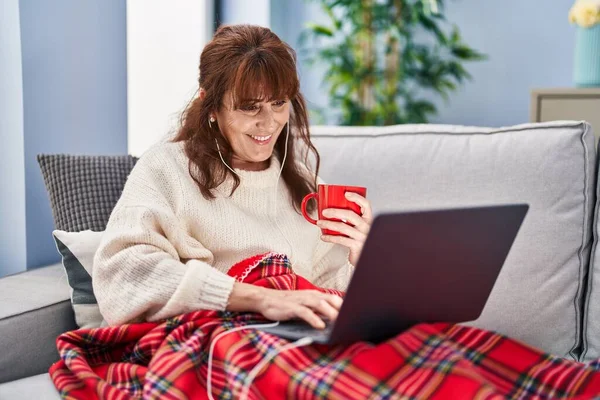 Middle Age Woman Watching Movie Drinking Coffee Sitting Sofa Home — Stockfoto