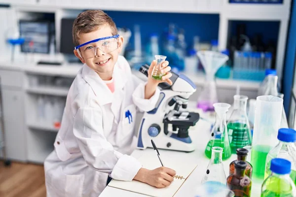 Blond Child Wearing Scientist Uniform Writing Notebook Laboratory — Stock fotografie