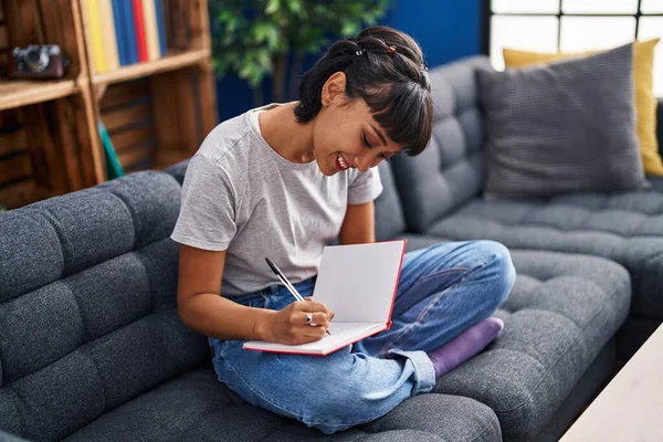 Νεαρή Γυναίκα Που Γράφει Στο Βιβλίο Κάθεται Στον Καναπέ Στο — Φωτογραφία Αρχείου