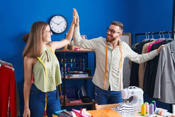 stock image Man and woman tailors high five with hands raised up at clothing factory
