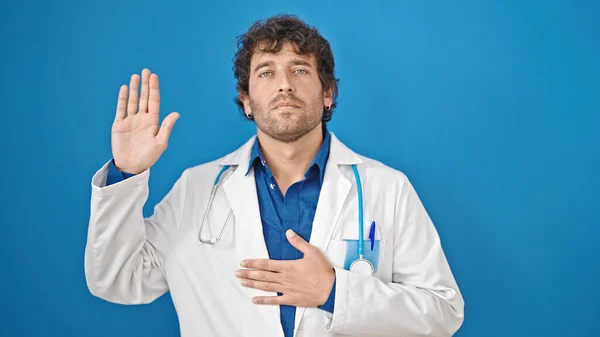 Young Hispanic Man Doctor Making Oath Hand Chest Isolated Blue — Stock Photo, Image
