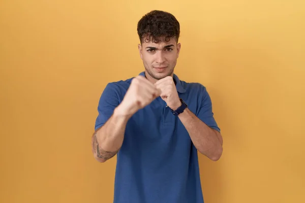 Young Hispanic Man Standing Yellow Background Punching Fist Fight Aggressive — ストック写真