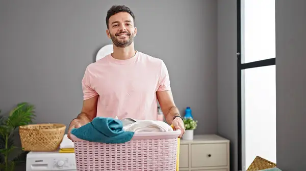 年轻人面带微笑 自信地拿着篮子 衣服在洗衣房里 — 图库照片