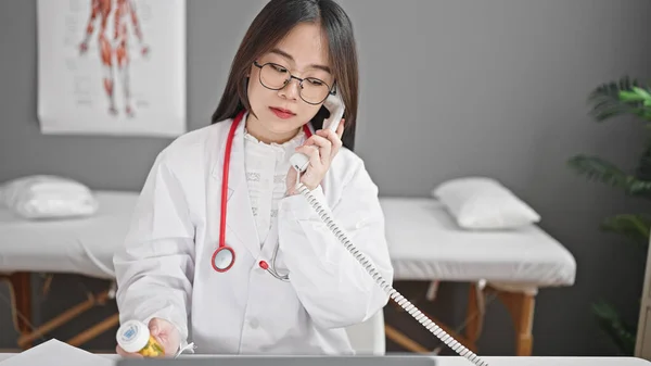 若い中国人女性医師はクリニックで電話で話す薬の治療を規定しています — ストック写真