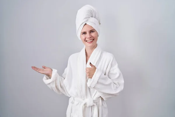 金发女人穿着浴衣 手牵着手 竖起大拇指 做着一个正常的动作 面带微笑 快乐而快乐 — 图库照片