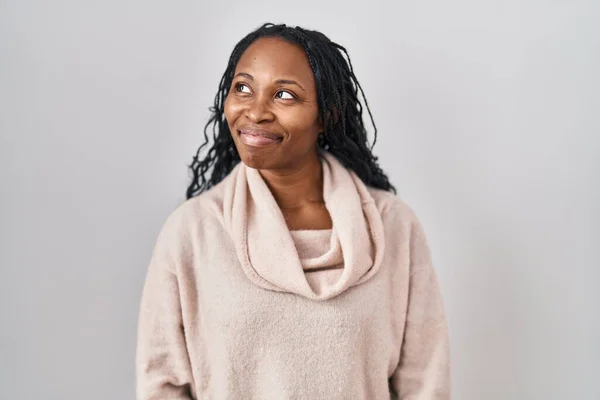 Afrikaanse Vrouw Staan Witte Achtergrond Glimlachen Kijken Naar Zijkant Staren — Stockfoto