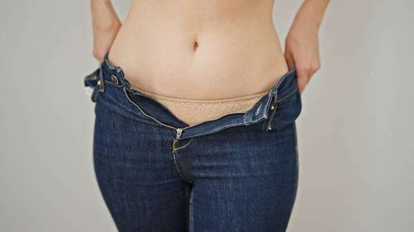 Молодая рыжая женщина в джинсах на изолированном белом фоне