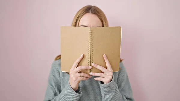 Молодая Блондинка Покрывает Лицо Книгой Изолированном Розовом Фоне — стоковое фото