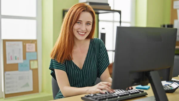 Młoda Ruda Kobieta Biznes Pracownik Pomocą Komputera Uśmiechnięty Biurze — Zdjęcie stockowe