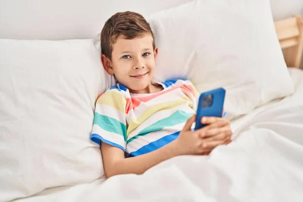 Criança Loira Usando Smartphone Deitado Cama Quarto — Fotografia de Stock