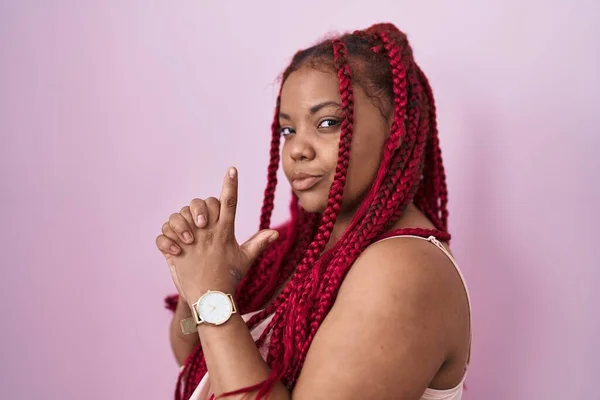 Африканская Американка Плетеными Волосами Стоящая Розовом Фоне Символическим Пистолетом Руках — стоковое фото
