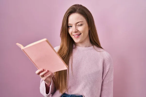 Νεαρή Καυκάσια Γυναίκα Που Διαβάζει Ένα Βιβλίο Πάνω Από Ροζ — Φωτογραφία Αρχείου