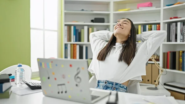 若い美しいですヒスパニック女性学生を使用してノートパソコンでリラックスした手で頭の上に大学の教室 — ストック写真