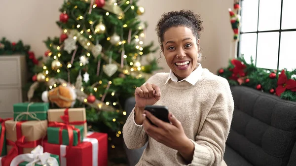Afro Amerikalı Kadın Akıllı Telefon Kullanıyor Evdeki Noel Ağacının Yanında — Stok fotoğraf