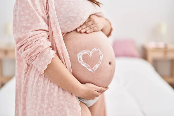 Young Pregnant Woman Touching Belly Heart Lotion Symbol Standing Bedroom — Stock Photo, Image